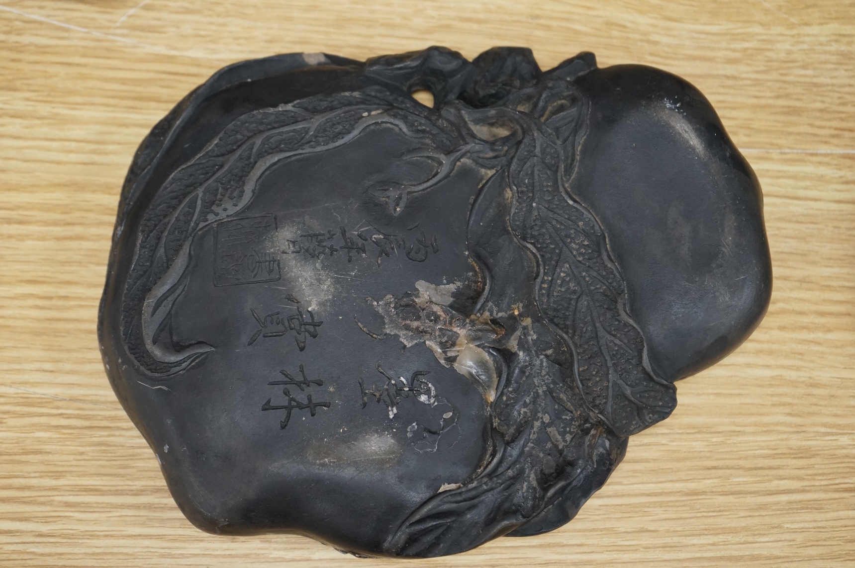 A Chinese carved inkstone, character marks to the base, 23cm